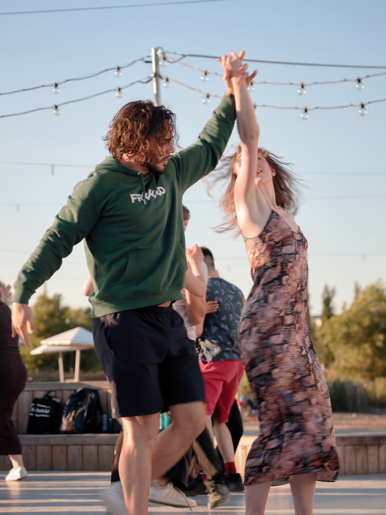 Dancers under festoon lights at the outdoor social